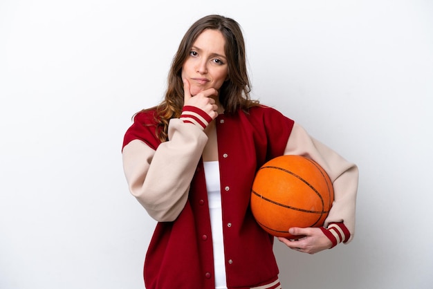 Jonge blanke vrouw die basketbal speelt geïsoleerd op een witte achtergrond