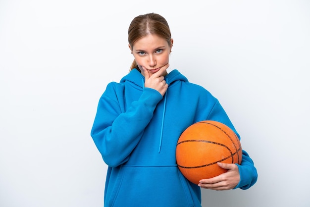 Jonge blanke vrouw die basketbal speelt geïsoleerd op een witte achtergrond