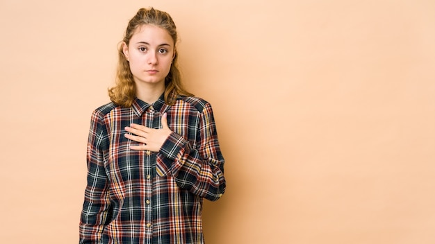 Jonge blanke vrouw die een eed aflegt, hand op de borst legt.