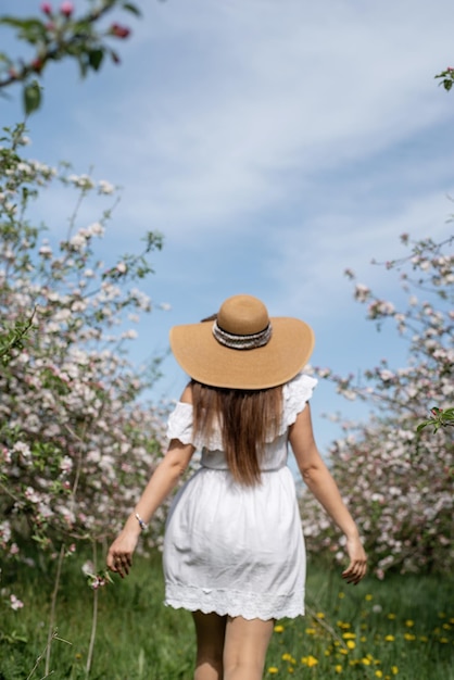 Jonge blanke vrouw die geniet van de bloei van een appelboom