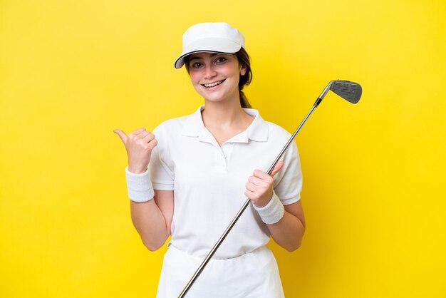 Jonge blanke vrouw die golf speelt geïsoleerd op een gele achtergrond die naar de zijkant wijst om een product te presenteren