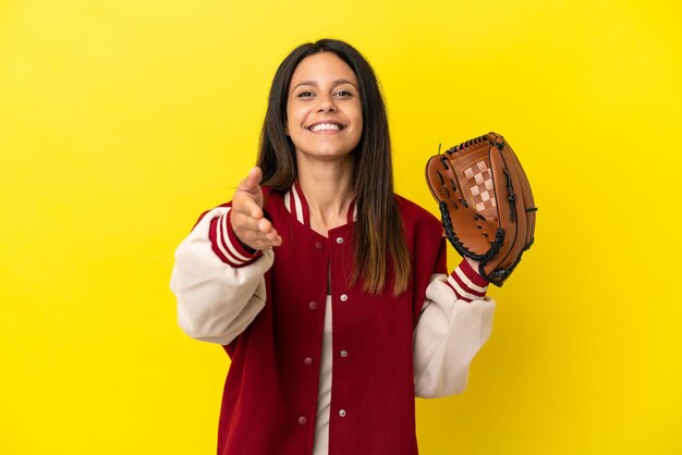 Jonge blanke vrouw die honkbal speelt geïsoleerd op gele achtergrond handen schudden voor het sluiten van een goede deal