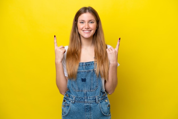 Jonge blanke vrouw die op gele achtergrond wordt geïsoleerd die een geweldig idee benadrukt