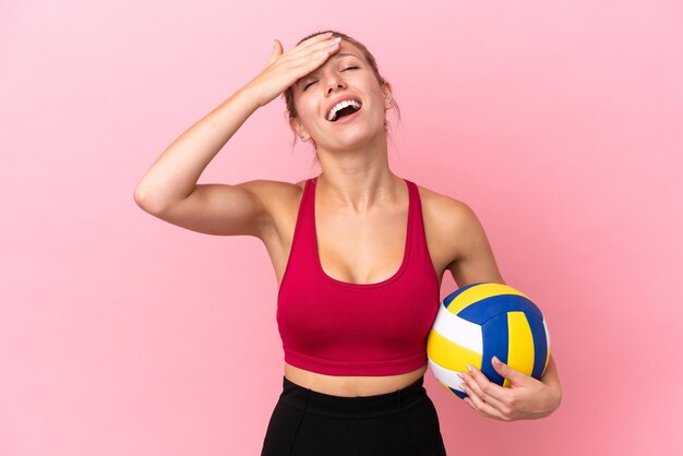 Jonge blanke vrouw die volleybal speelt geïsoleerd op roze achtergrond heeft iets gerealiseerd en heeft de oplossing voor ogen