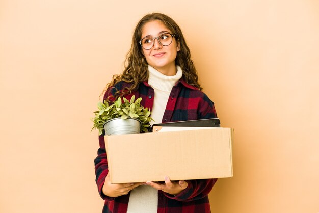 Jonge blanke vrouw die zich met een geïsoleerde doos beweegt