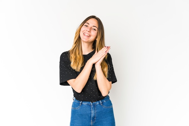 Jonge blanke vrouw die zich op een witte ruimte energiek en comfortabel voelt, zelfverzekerd handen wrijft.