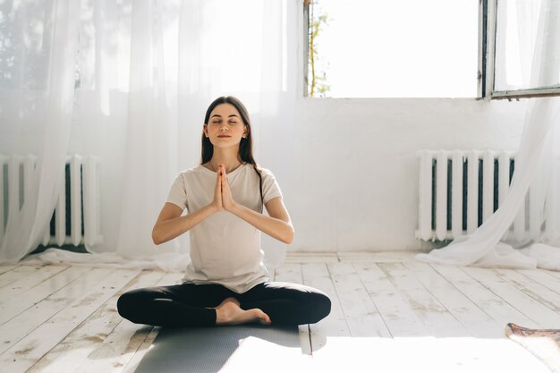 Jonge blanke vrouw doet yoga thuis