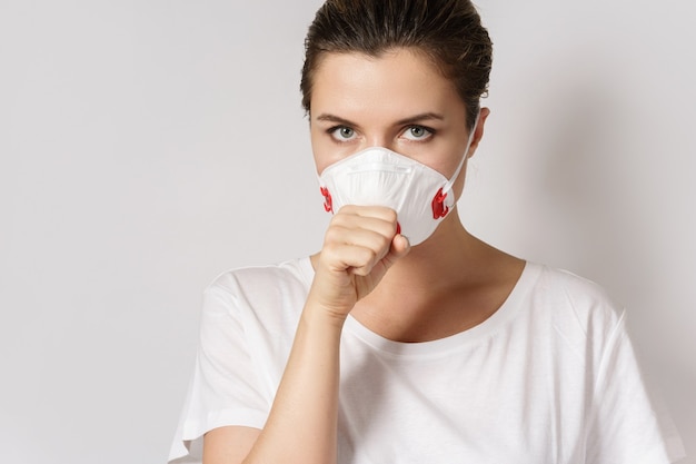 Jonge blanke vrouw draagt een gezichtsmasker ter bescherming tegen virussen