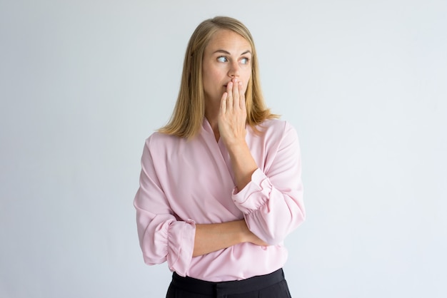 jonge blanke vrouw draagt ​​roze blouse die betrekking hebben op mond bang om een ​​woord te zeggen