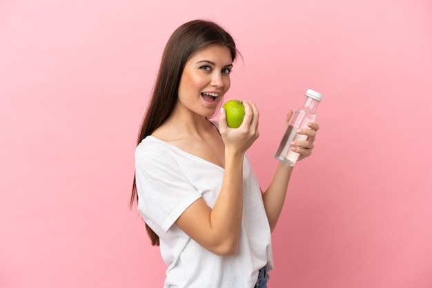 Jonge blanke vrouw geïsoleerd met een appel en met een fles water