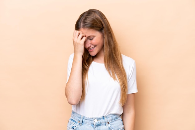 Jonge blanke vrouw geïsoleerd op beige achtergrond lachen