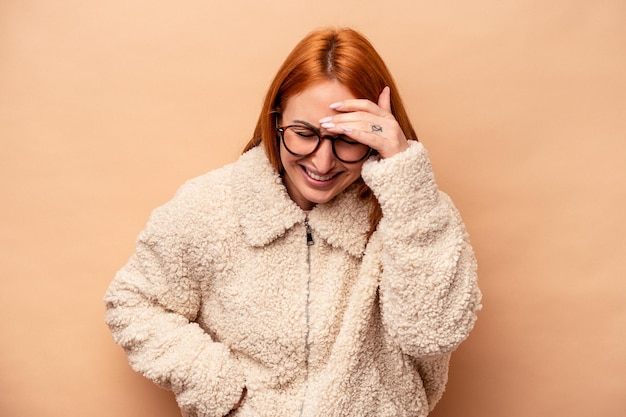 Jonge blanke vrouw geïsoleerd op beige achtergrond vrolijk veel lachen. Geluk concept.