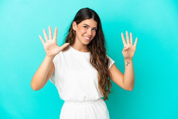Jonge blanke vrouw geïsoleerd op blauwe achtergrond die negen met vingers telt