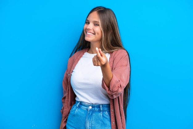 Jonge blanke vrouw geïsoleerd op blauwe achtergrond geld gebaar maken