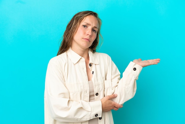 Jonge blanke vrouw geïsoleerd op blauwe achtergrond met twijfels