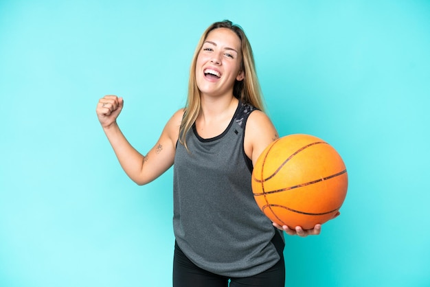 Jonge blanke vrouw geïsoleerd op blauwe achtergrond spelen basketbal