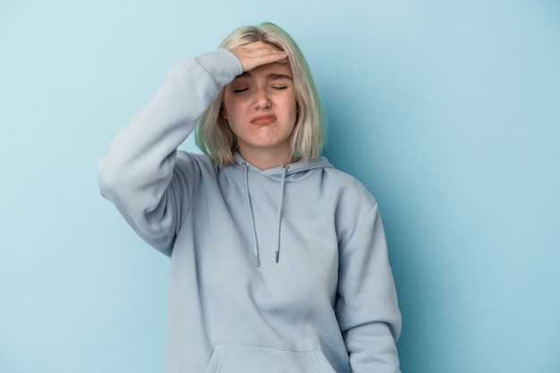 Foto jonge blanke vrouw geïsoleerd op blauwe achtergrond tempels aan te raken en hoofdpijn te hebben.