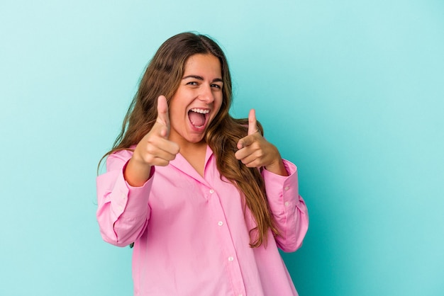 Jonge blanke vrouw geïsoleerd op blauwe achtergrond vrolijke glimlach wijzend naar voren.