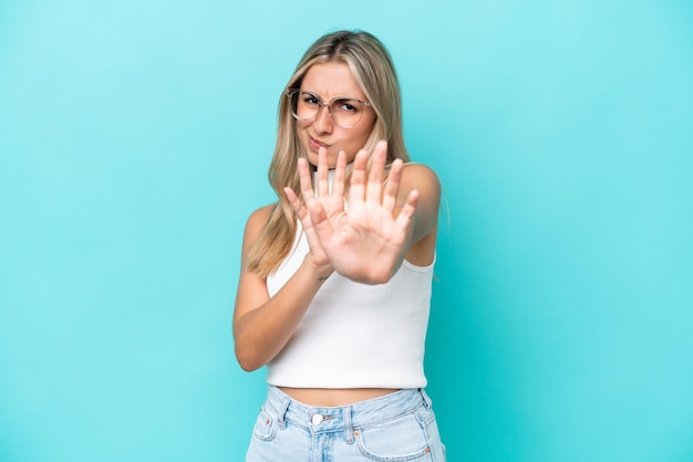 Jonge blanke vrouw geïsoleerd op blauwe achtergrond zenuwachtige handen naar voren strekken