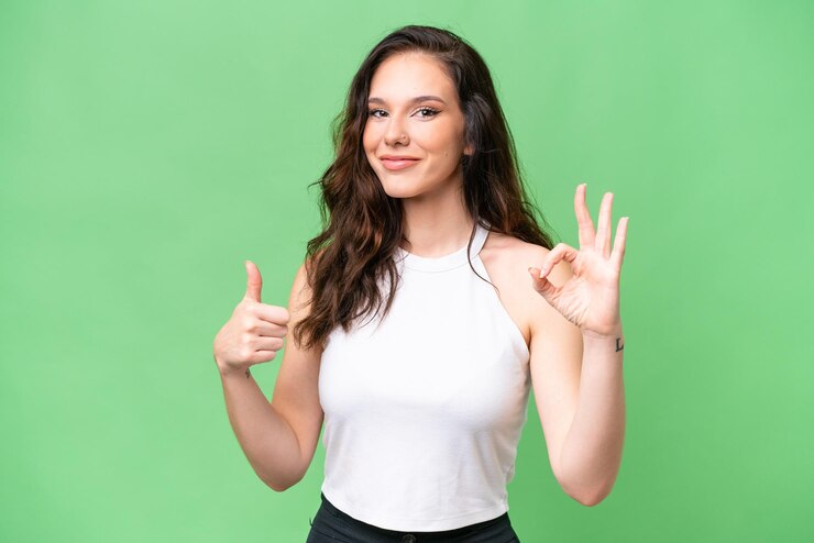 Foto jonge blanke vrouw geïsoleerd op een geïsoleerde achtergrond met ok-teken en duim omhoog gebaar