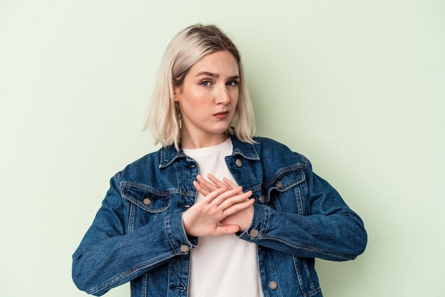 Jonge blanke vrouw geïsoleerd op een groene achtergrond die een ontkenningsgebaar doet