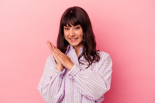 Jonge blanke vrouw geïsoleerd op een roze achtergrond energiek en comfortabel gevoel, handen zelfverzekerd wrijven.