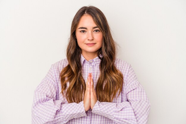 Jonge blanke vrouw geïsoleerd op een witte achtergrond bidden, tonen toewijding, religieuze persoon op zoek naar goddelijke inspiratie.