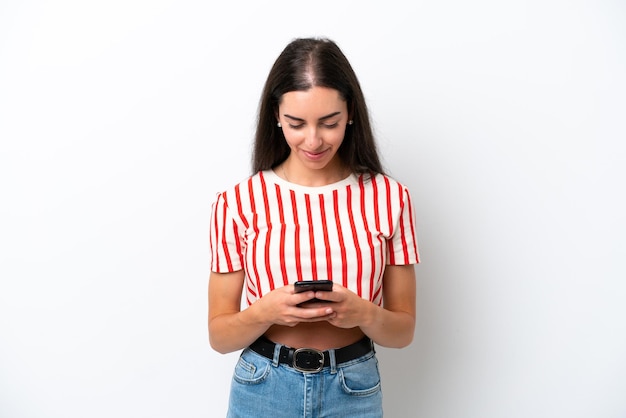 Jonge blanke vrouw geïsoleerd op een witte achtergrond die een bericht verzendt met de mobiel