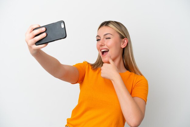 Jonge blanke vrouw geïsoleerd op een witte achtergrond die een selfie maakt met mobiele telefoon