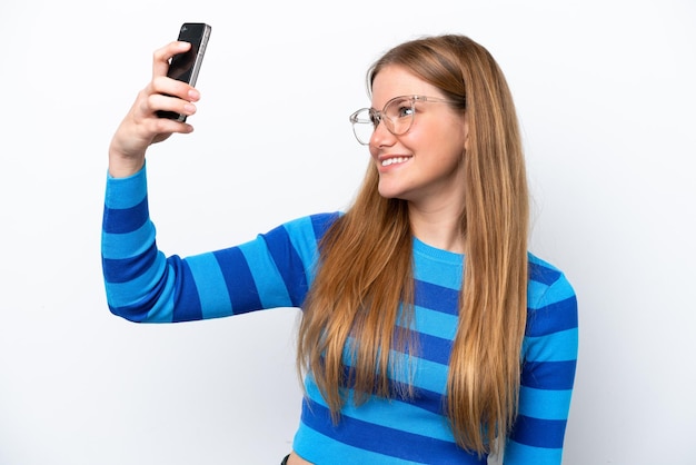 Jonge blanke vrouw geïsoleerd op een witte achtergrond die een selfie maakt