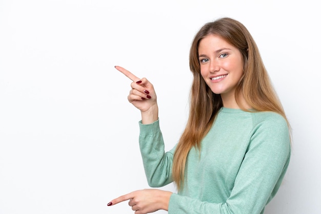 Jonge blanke vrouw geïsoleerd op een witte achtergrond die met de vinger naar de zijkant wijst en een product presenteert