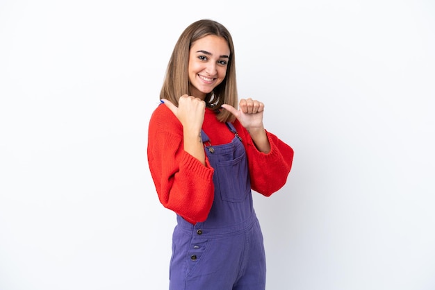 Jonge blanke vrouw geïsoleerd op een witte achtergrond die naar de zijkant wijst om een product te presenteren