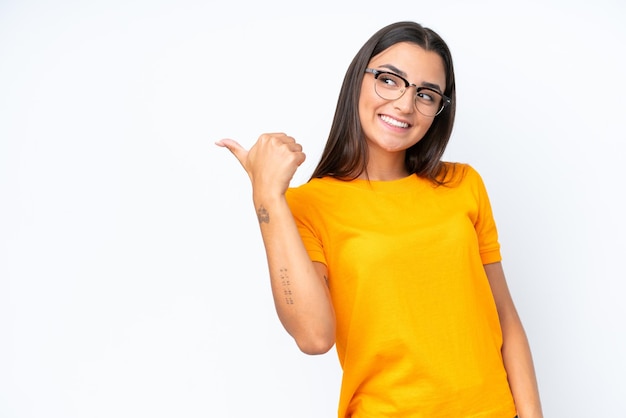 Jonge blanke vrouw geïsoleerd op een witte achtergrond die naar de zijkant wijst om een product te presenteren