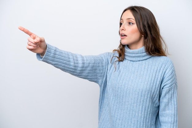 Jonge blanke vrouw geïsoleerd op een witte achtergrond die weg wijst