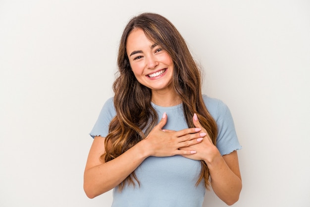 Jonge blanke vrouw geïsoleerd op een witte achtergrond heeft vriendelijke uitdrukking, palm op de borst te drukken. liefdesconcept.