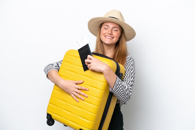 Jonge blanke vrouw geïsoleerd op een witte achtergrond in vakantie met koffer en paspoort