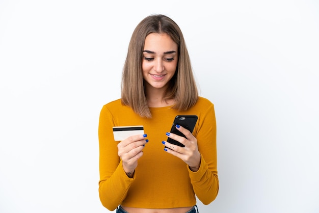 Jonge blanke vrouw geïsoleerd op een witte achtergrond kopen met de mobiel met een creditcard