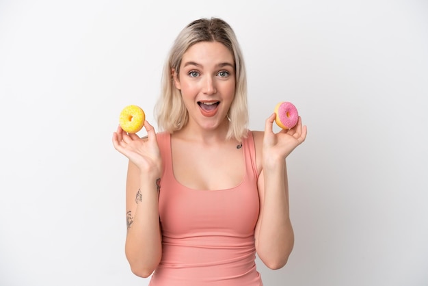 Jonge blanke vrouw geïsoleerd op een witte achtergrond met donuts met gelukkige expressie