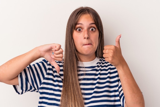 Jonge blanke vrouw geïsoleerd op een witte achtergrond met duimen omhoog en duim omlaag, moeilijk kies concept