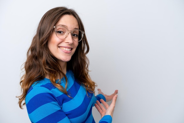 Jonge blanke vrouw geïsoleerd op een witte achtergrond Met een bril en iets presenteren