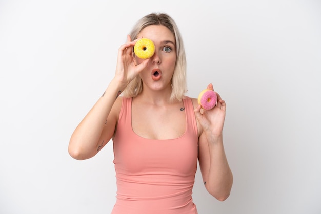 Jonge blanke vrouw geïsoleerd op een witte achtergrond met een donut in een oog