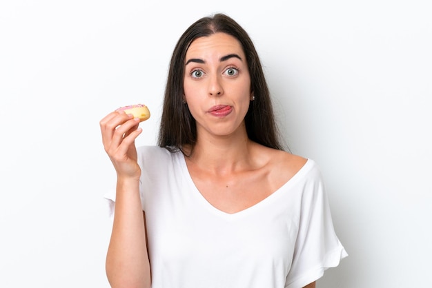 Jonge blanke vrouw geïsoleerd op een witte achtergrond met een donut