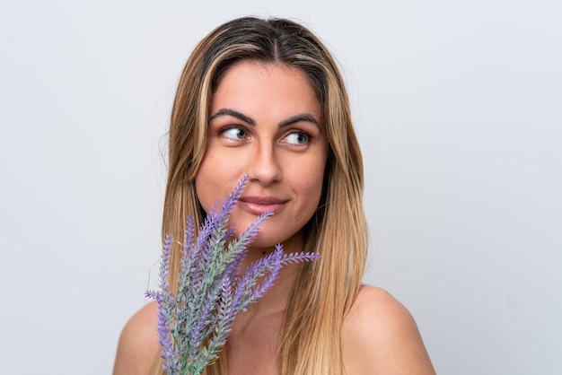 Jonge blanke vrouw geïsoleerd op een witte achtergrond met een lavendelplant Close-up portret