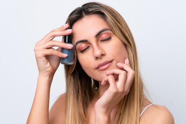 Jonge blanke vrouw geïsoleerd op een witte achtergrond met een serum Close-up portret