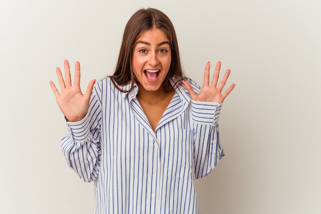 Jonge blanke vrouw geïsoleerd op een witte achtergrond met iets kleins met wijsvingers, glimlachend en zelfverzekerd.