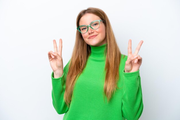 Jonge blanke vrouw geïsoleerd op een witte achtergrond met overwinningsteken met beide handen