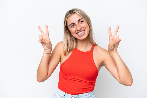 Jonge blanke vrouw geïsoleerd op een witte achtergrond met overwinningsteken met beide handen