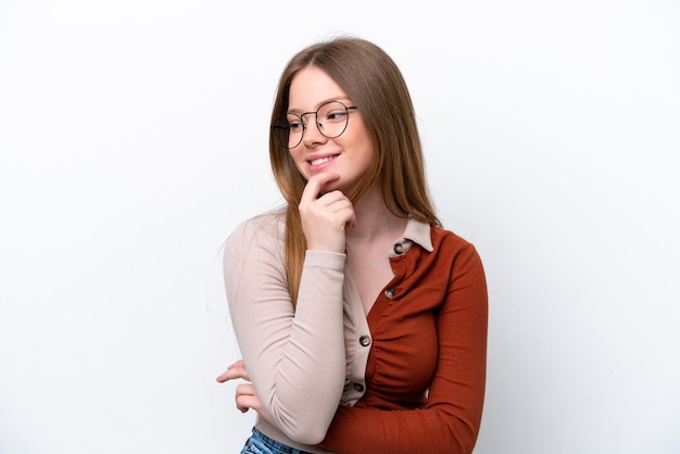 Jonge blanke vrouw geïsoleerd op een witte achtergrond op zoek naar de kant en lachend