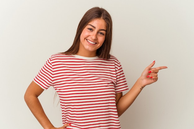 Jonge blanke vrouw geïsoleerd op een witte achtergrond opgewonden wijzend met wijsvingers weg.