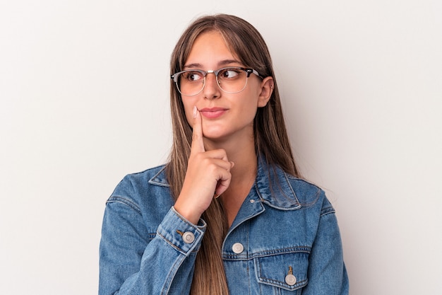 Jonge blanke vrouw geïsoleerd op een witte achtergrond overweegt, het plannen van een strategie, denken over de manier van een bedrijf.